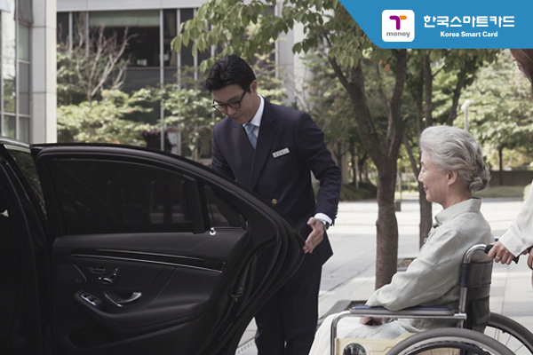 휠체어를 타고 있는 사람을 위해 차문을 여는 기사